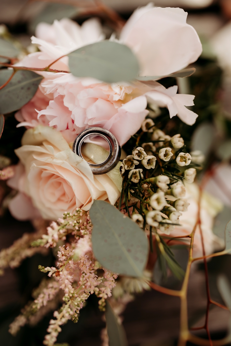 two wedding rings on the brides bouquet