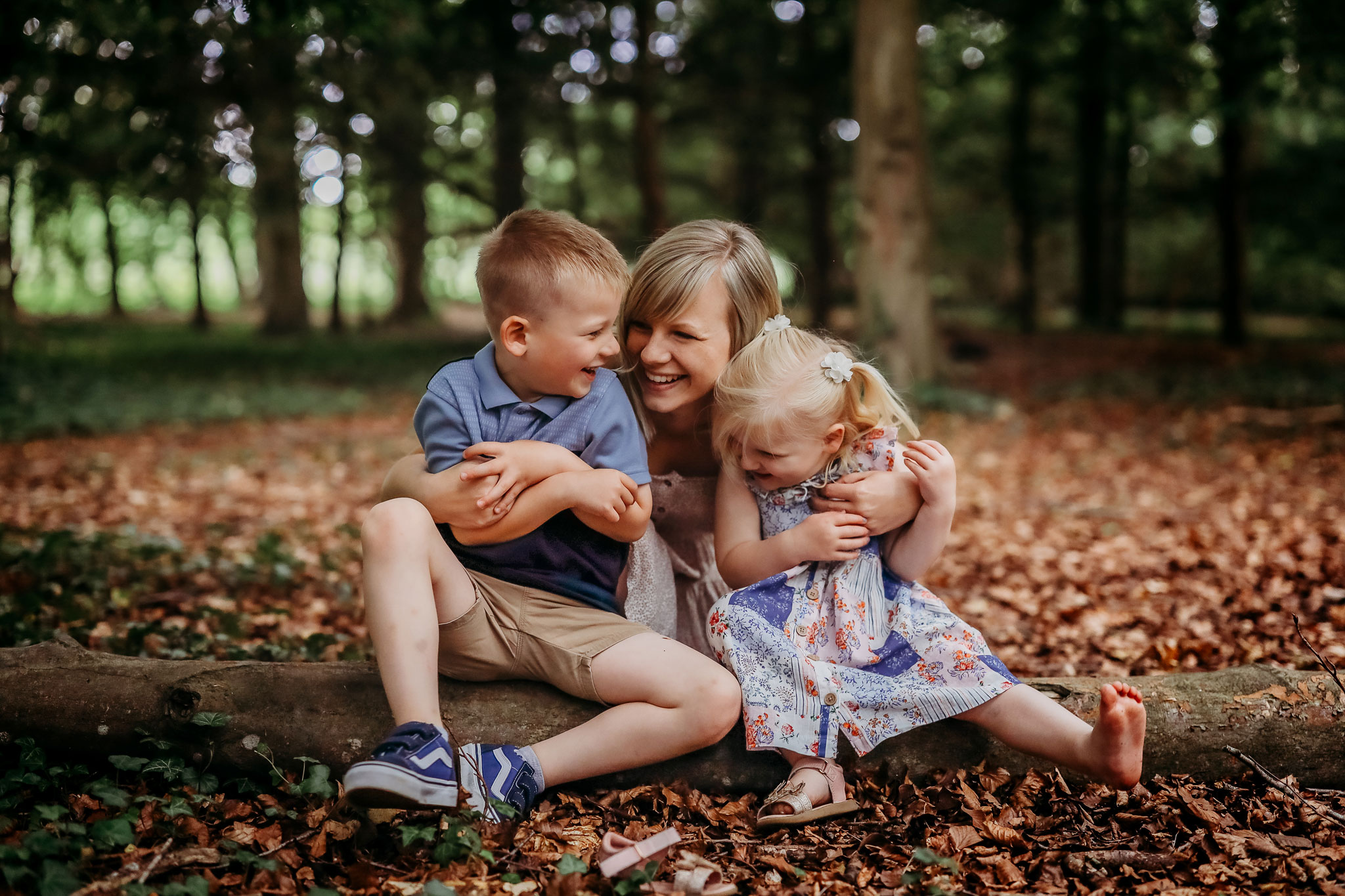 hampshire family photography a mum cuddling her two children in the woods