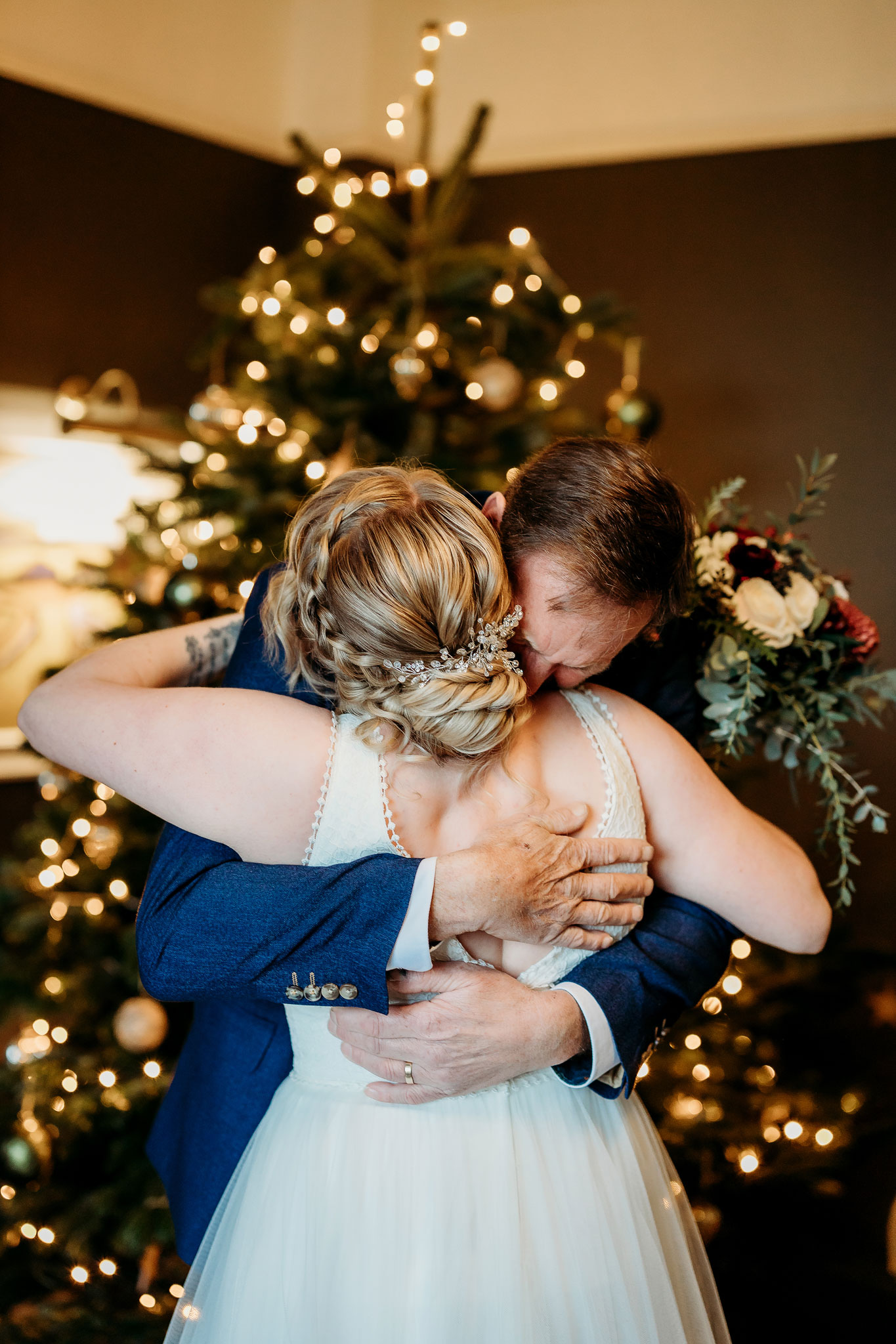 the father of the bride and bride hugging