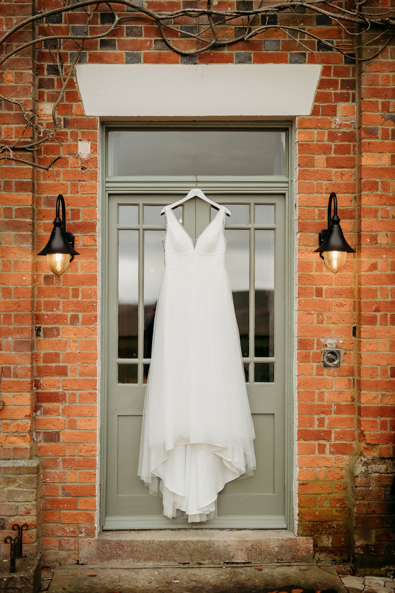 the wedding dress hung up on the green door