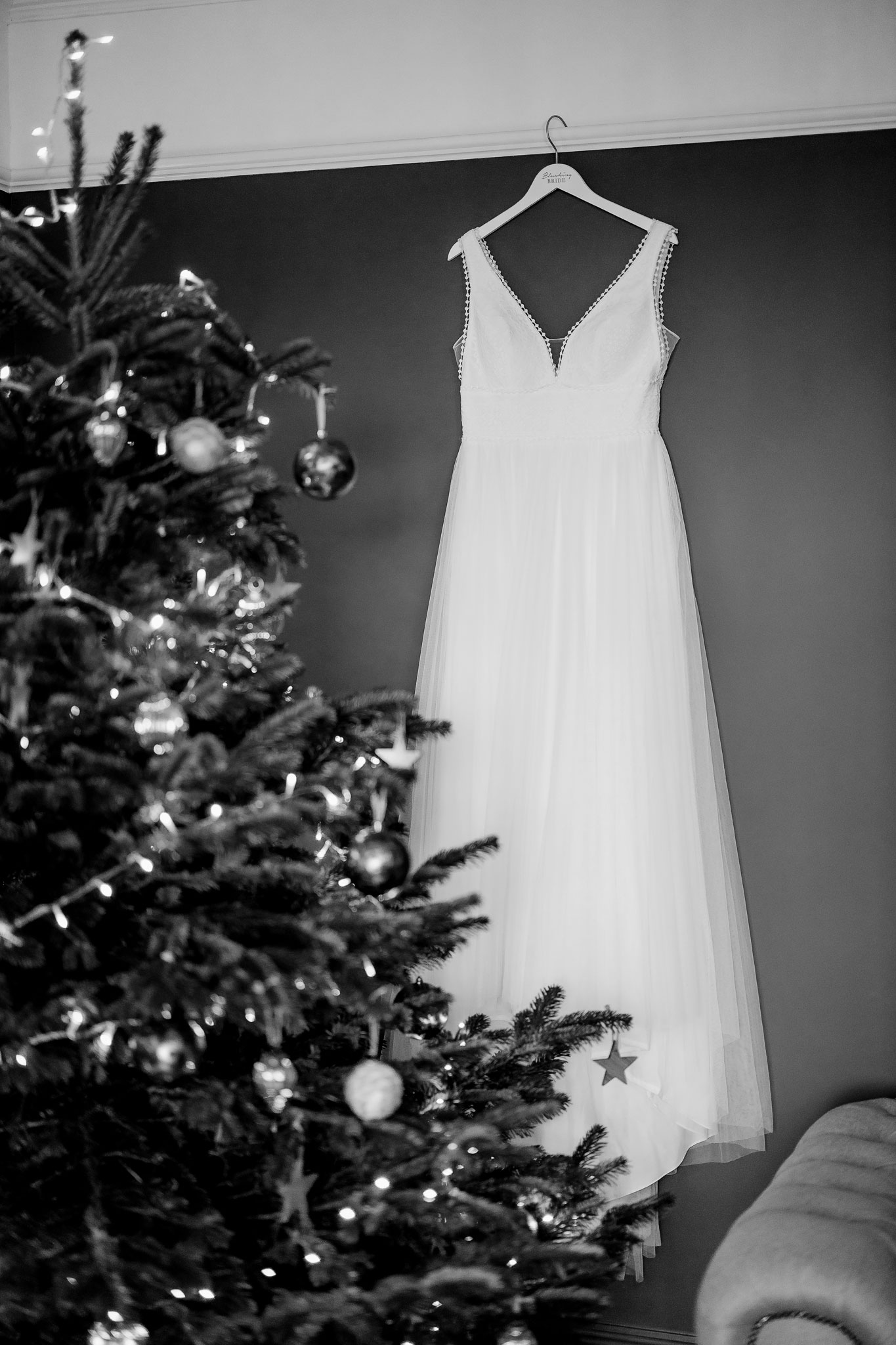 the brides dress hung up by the Christmas tree