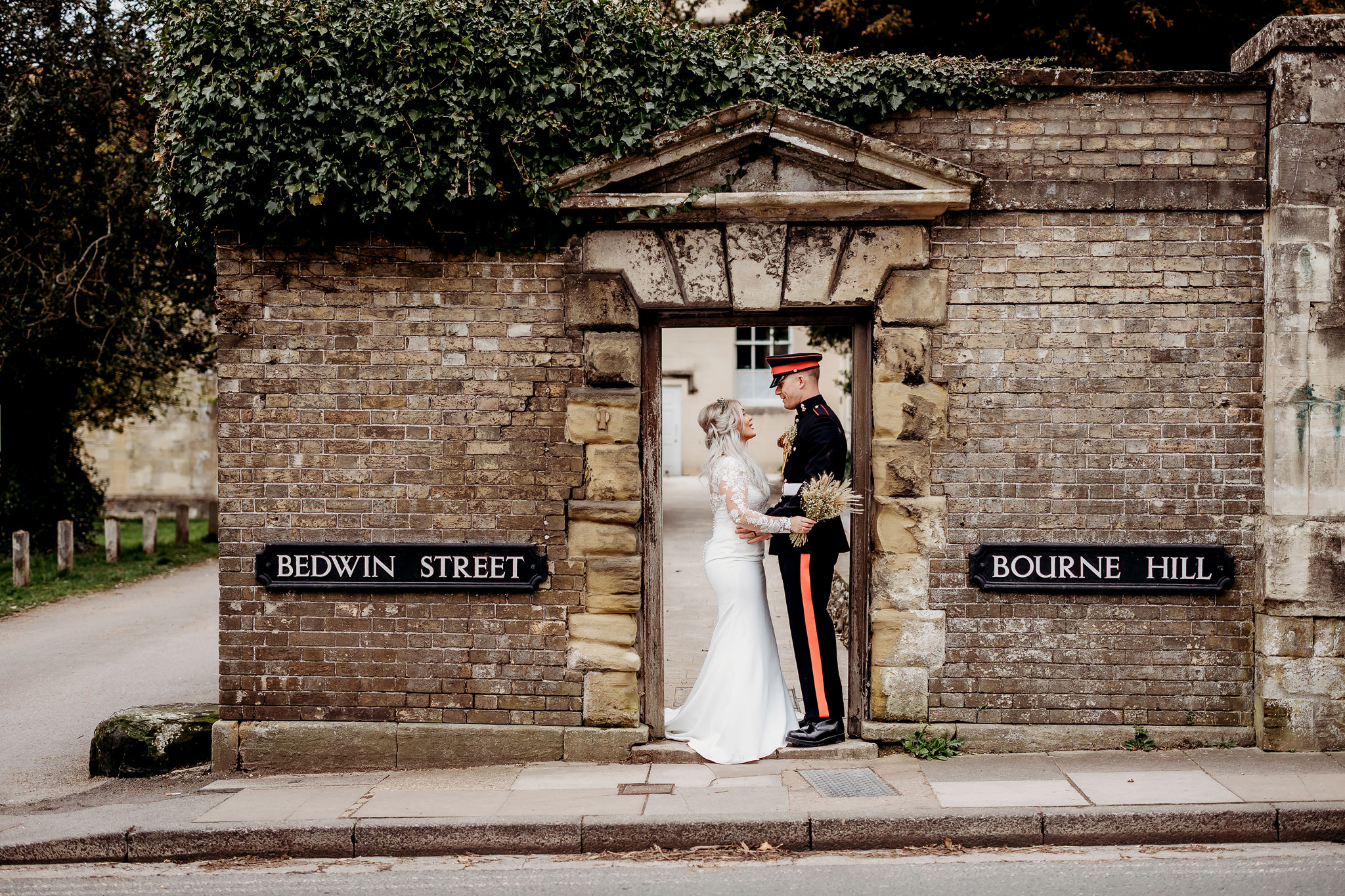 The bride and groom standing under a archway at salisbury registry office