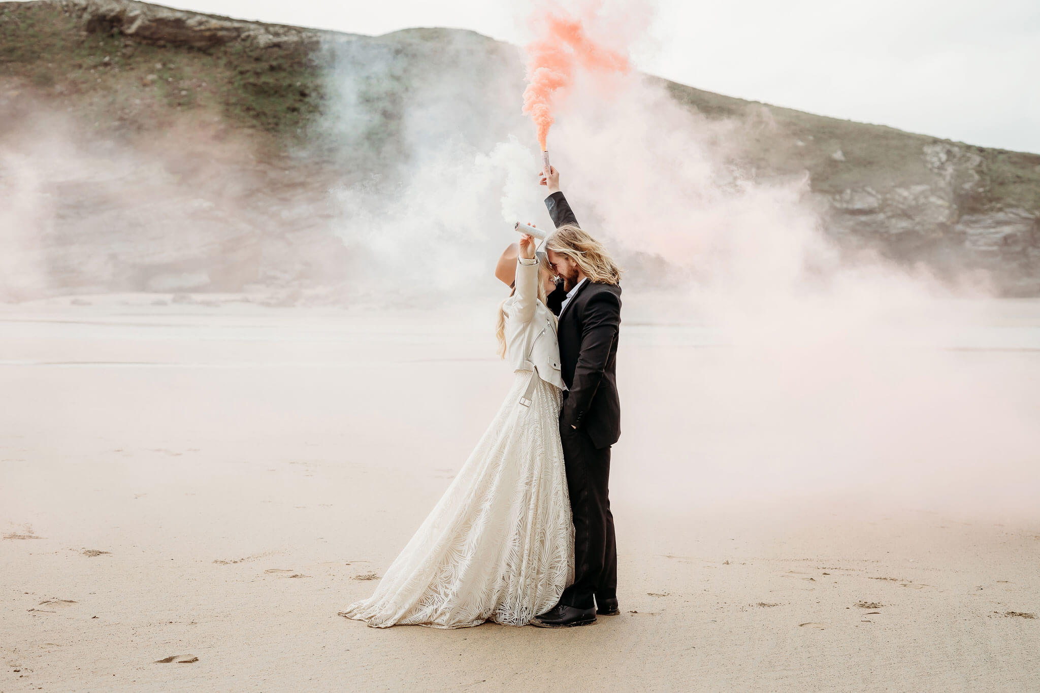 a bride and groom using smoke bombs in Cornwall