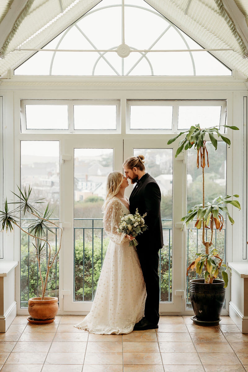 a bride and groom having a intimate photo in a conservatory
