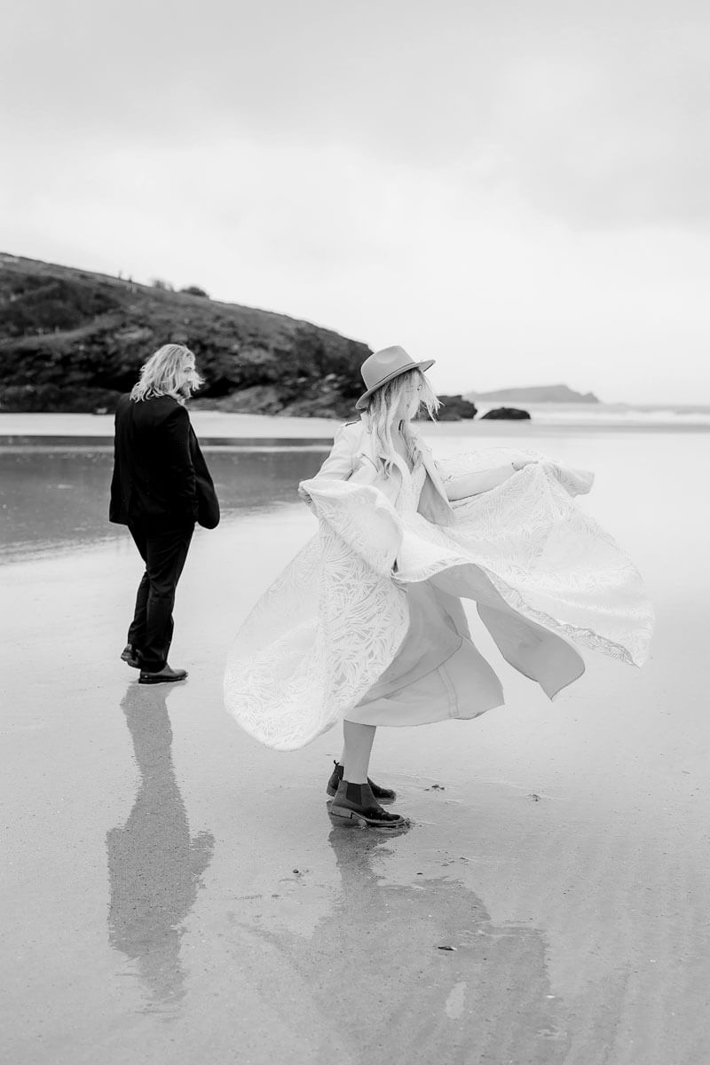 a bride and groom twirling on the beach in Cornwall