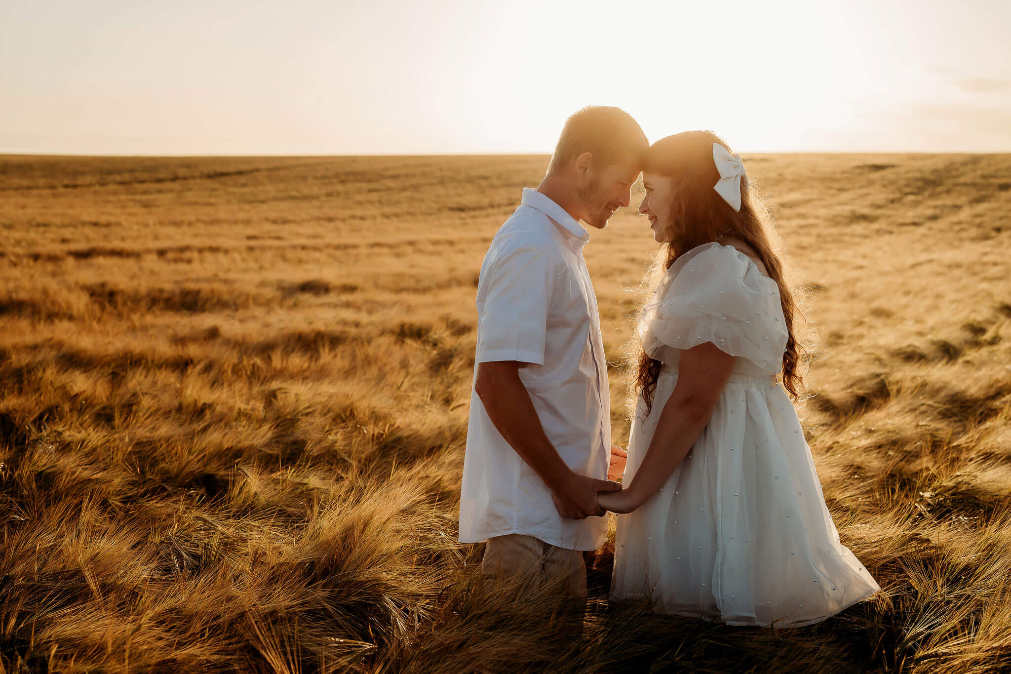 a happy engaged couple in a wheat field