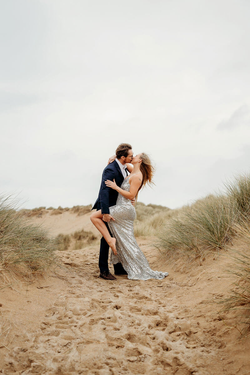 a happy engaged couple on the beach
