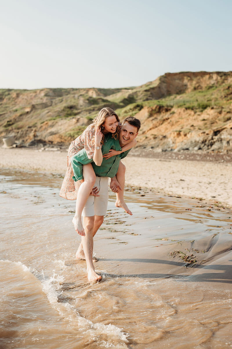 a happy engaged couple on the beach in the sea