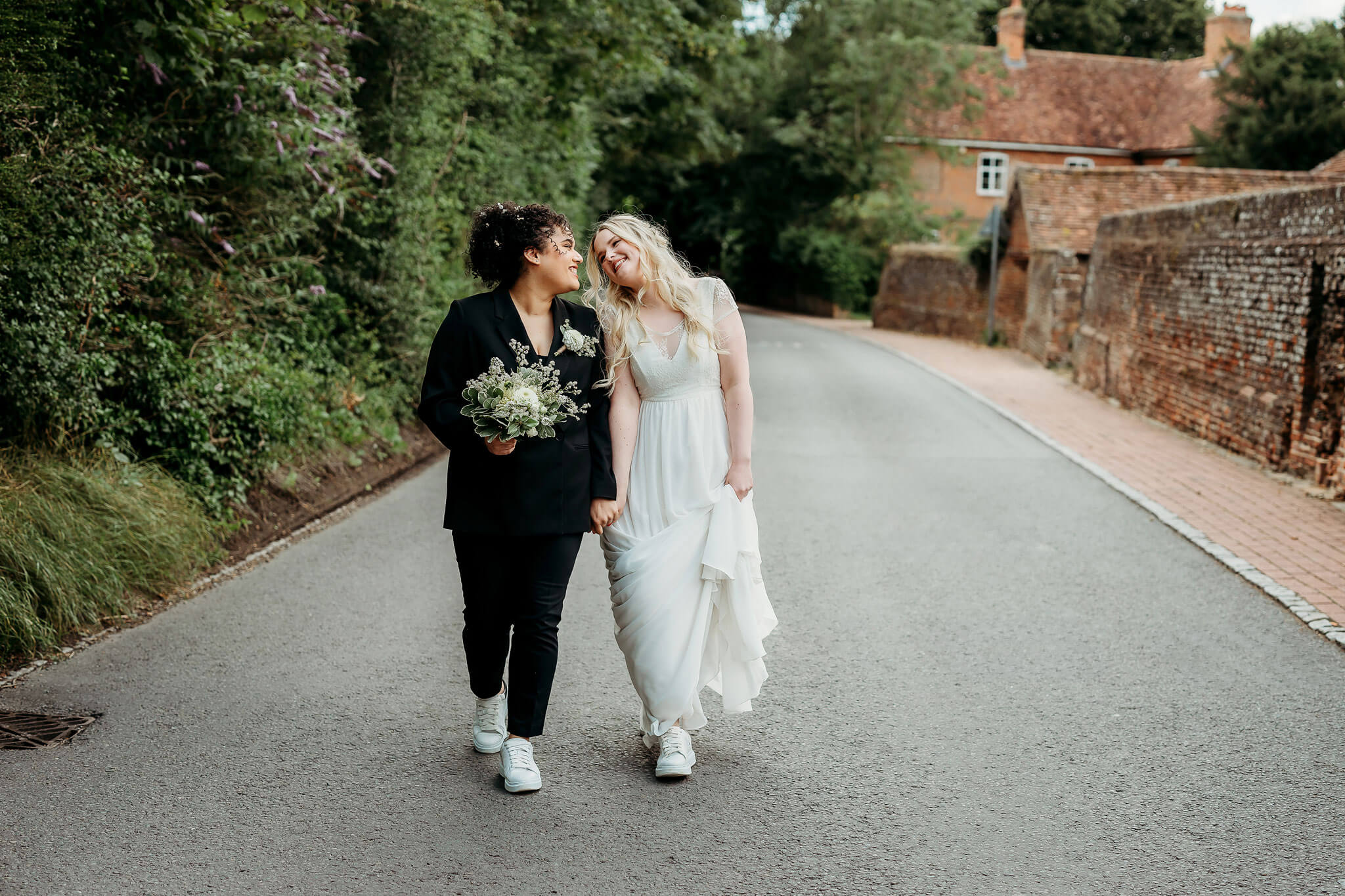 a bride and bride walking down the road