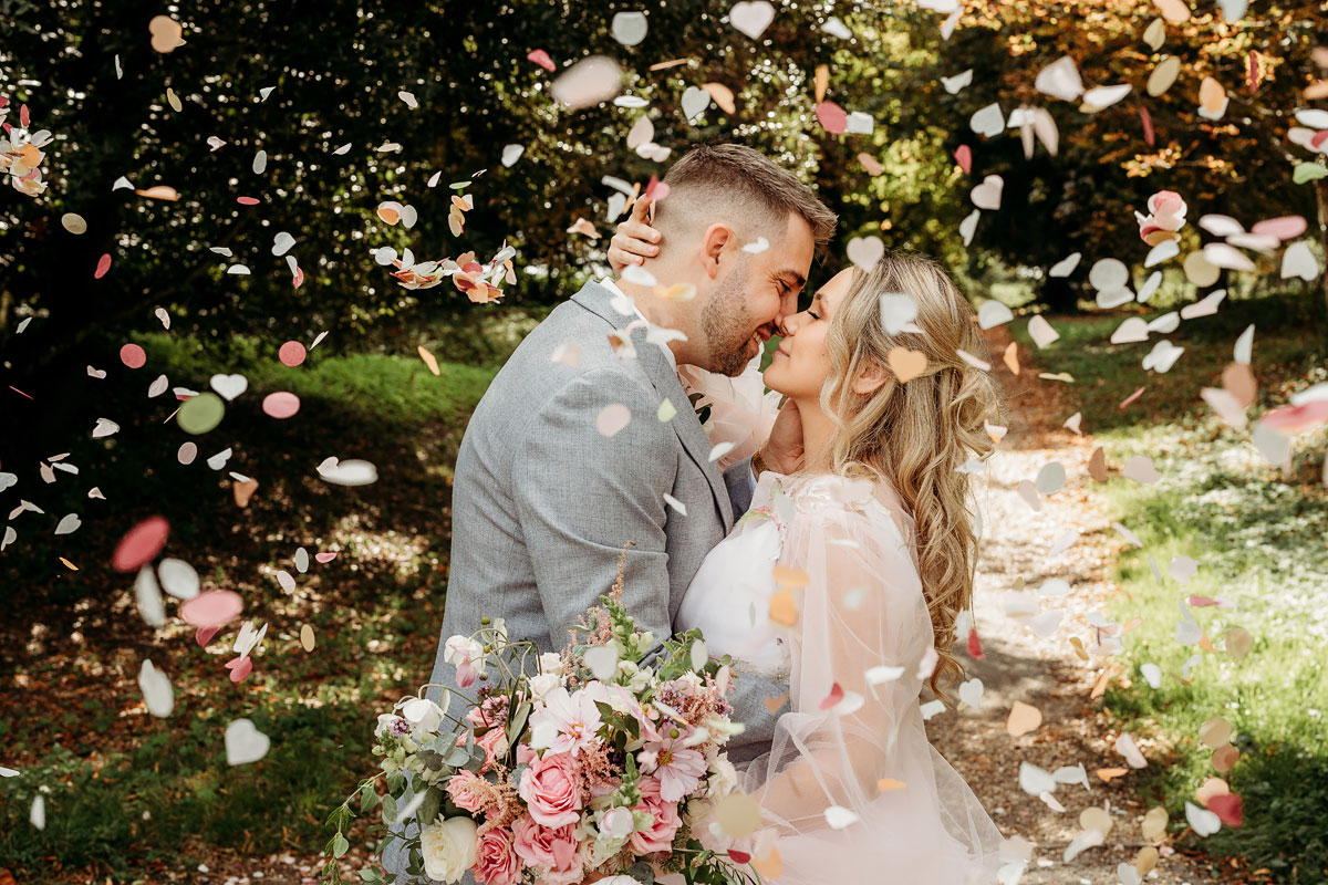 a bride and groom kissing in confetti