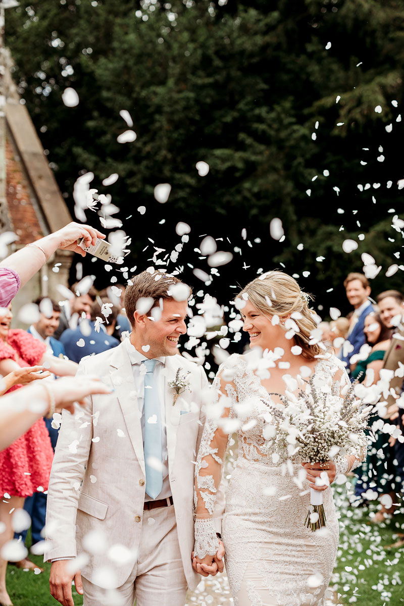 a bride and groom enjoying their biodegradable confetti tunnel