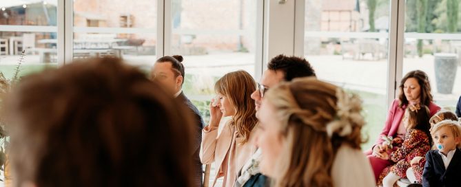 a wedding day photographer capturing the sister crying at her brothers wedding