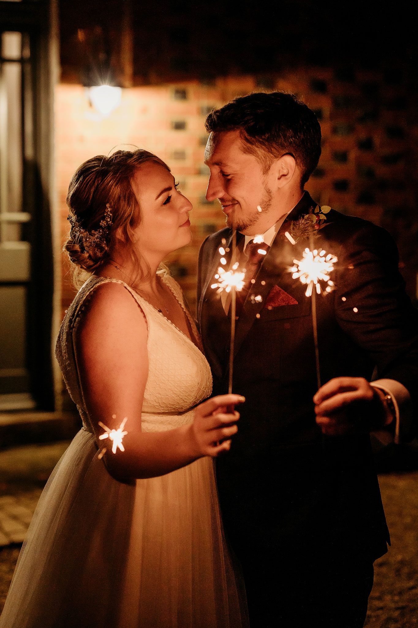 a couple smiling for there sparkler wedding photos