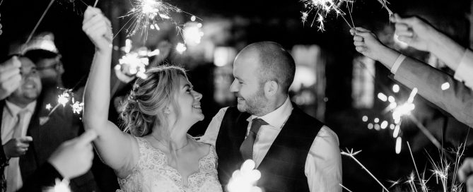 a couple smiling for there sparkler wedding photos