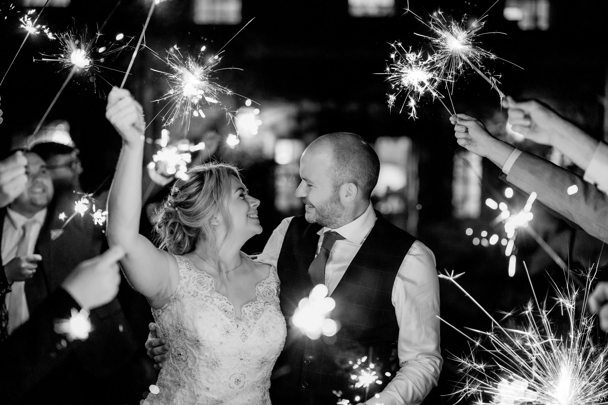 a couple smiling for there sparkler wedding photos