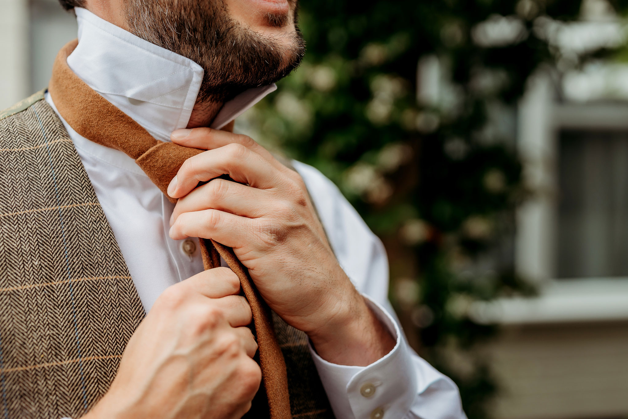 a groom tying his tie