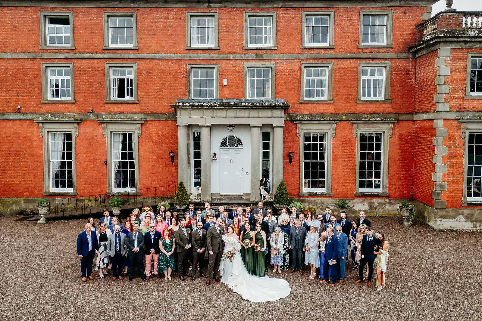 drone photo of wedding guests a arial photo of everyone standing in front of the venue