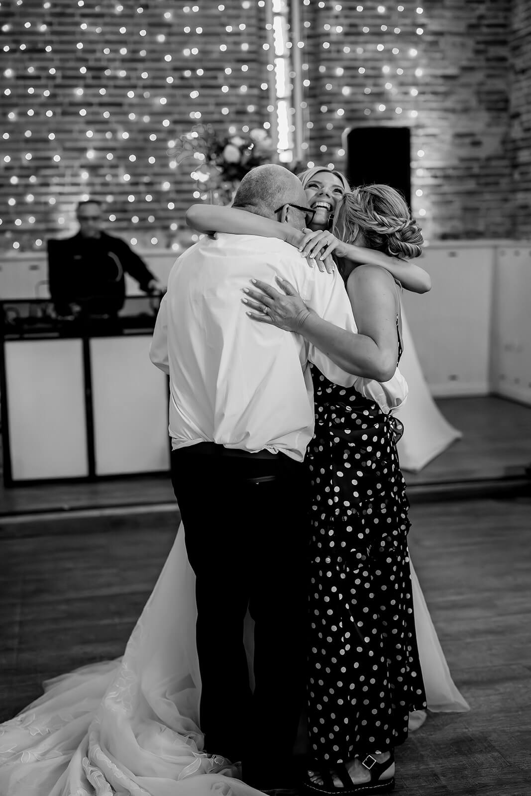 bride and family hugging and smiling