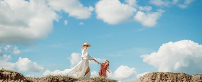 a mum and daughter walking naturally for their family photoshoot in hampshire along the cliff edge