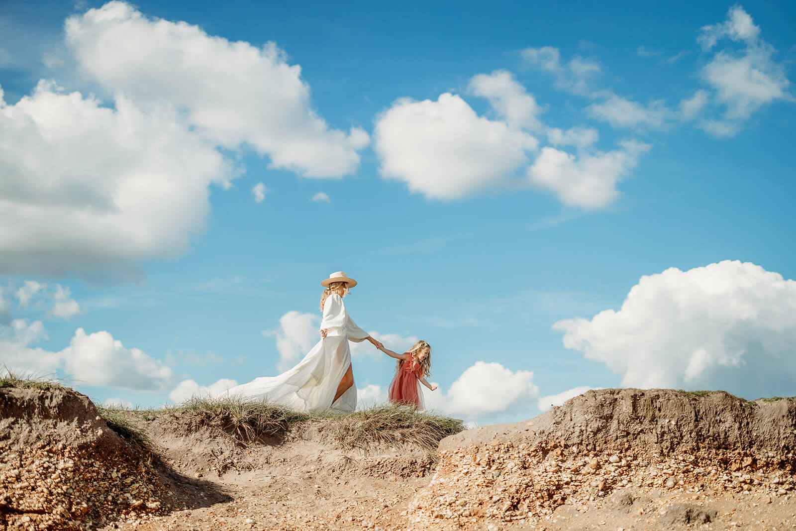 a mum and daughter walking naturally for their family photoshoot in hampshire along the cliff edge