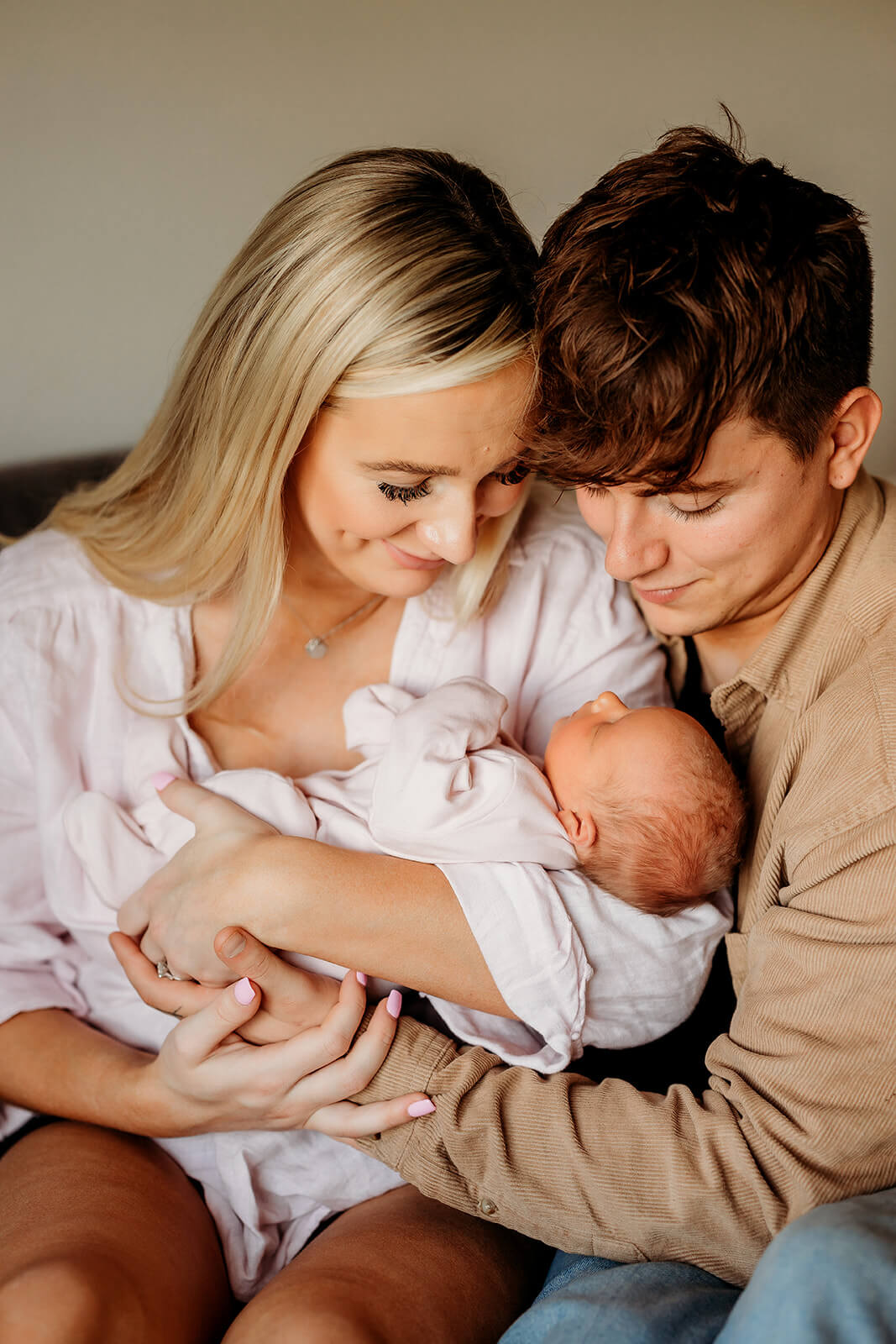 a mum and dad holding the baby in their arms
