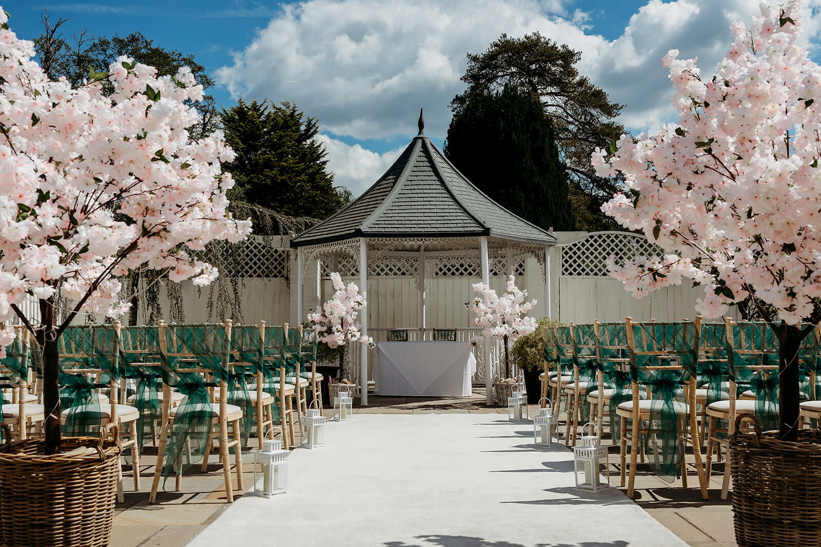 an outdoor ceremony setup with pink blossom trees