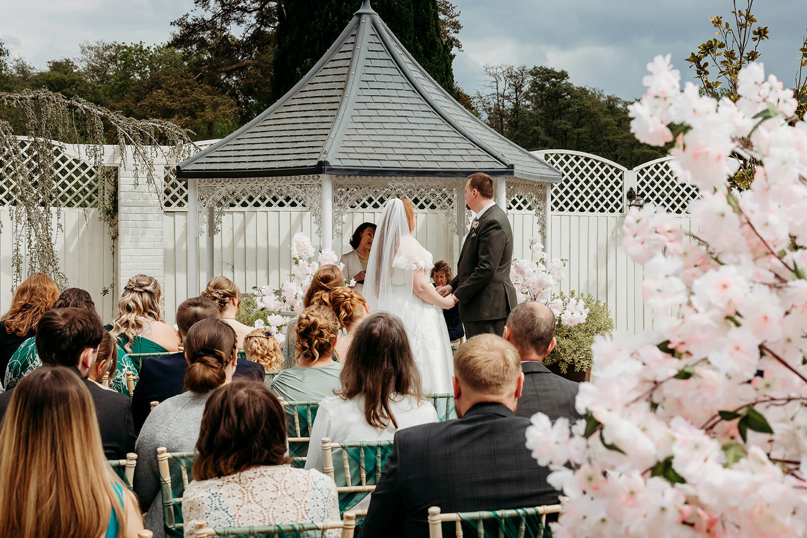 an outdoor ceremony with bride and groom looking at each other