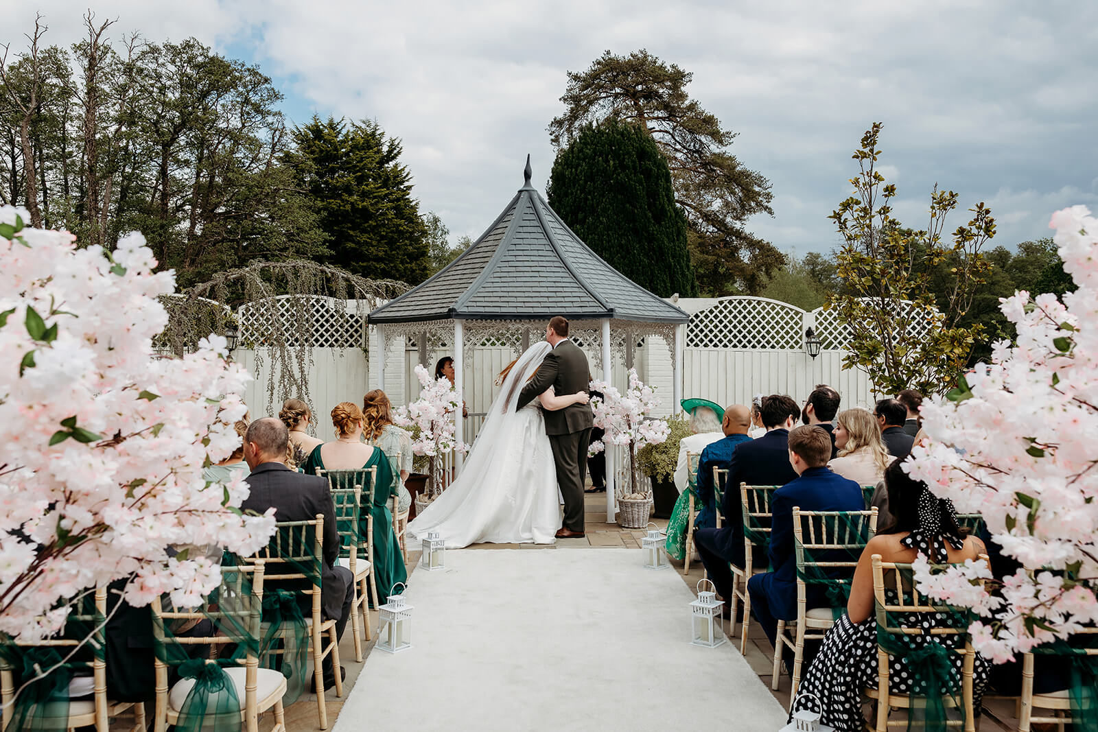 outdoor ceremony setup with bride and groom hugging at the alter